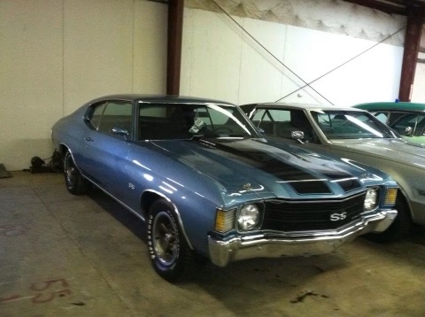 Blue Chevrolet SS muscle car displayed in indoor garage with other vehicles