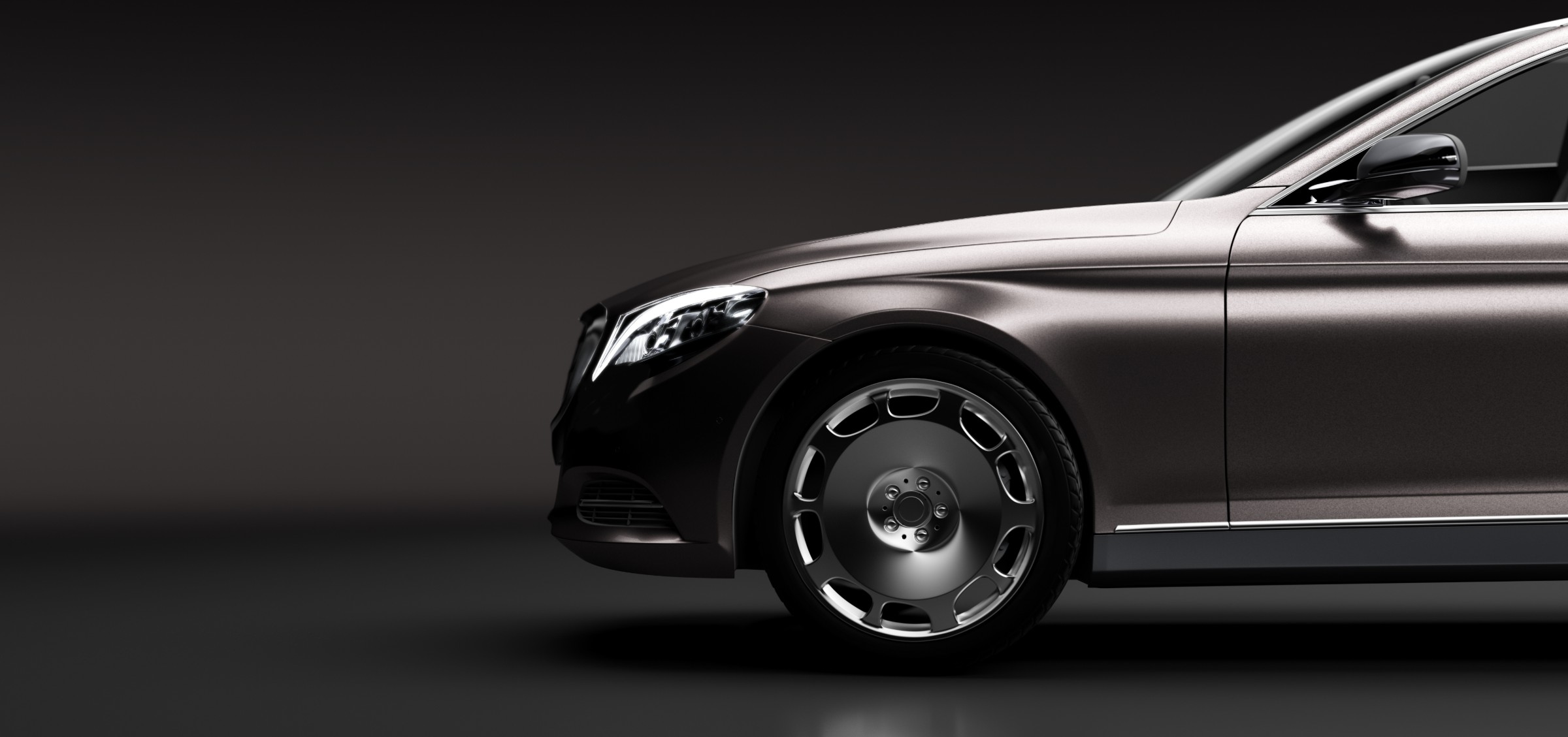 Silver luxury sedan photographed from the side against a dark background